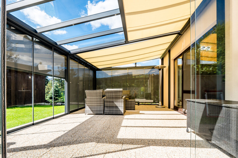 Schöne Terrassenüberdachung mit integrierter Markise als Sonnenschutz